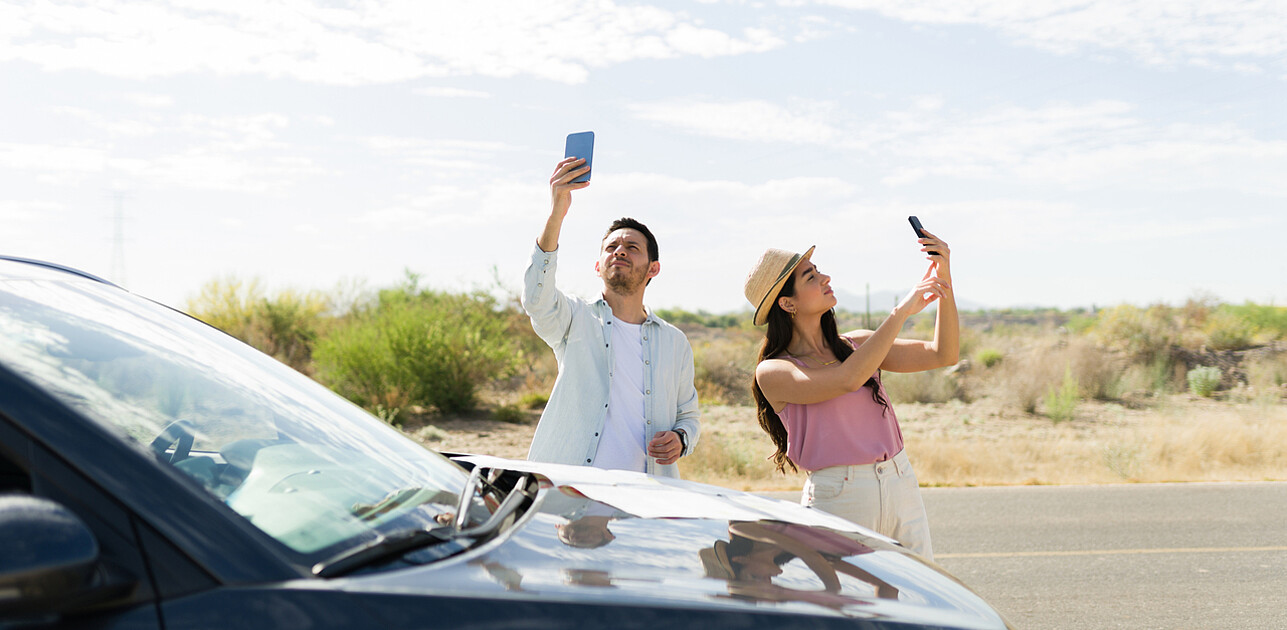 Two people looking for a signal on their phones