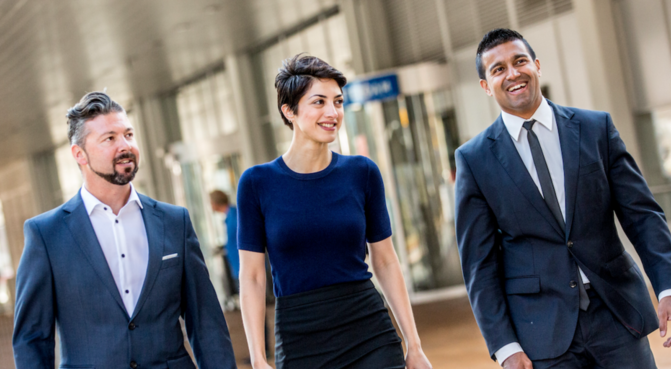 Three MBA students, one woman, two men, walking next to each other