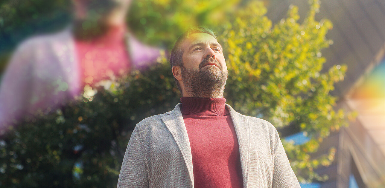 A man standing in Rotterdam with prisms around him.