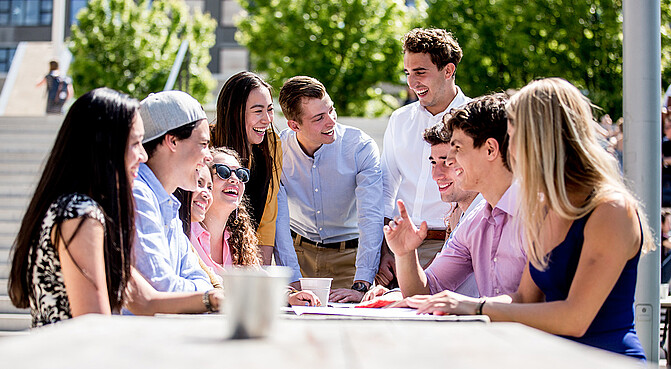 Students talking to each other at the table outside