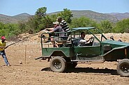 a jeep driving with people in it