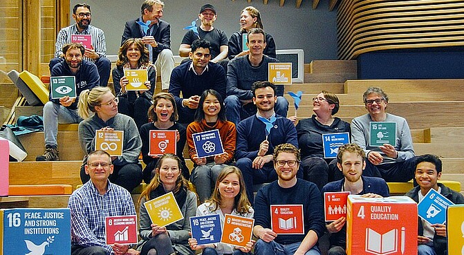 People with SDG's sgins making a Positive Change impact