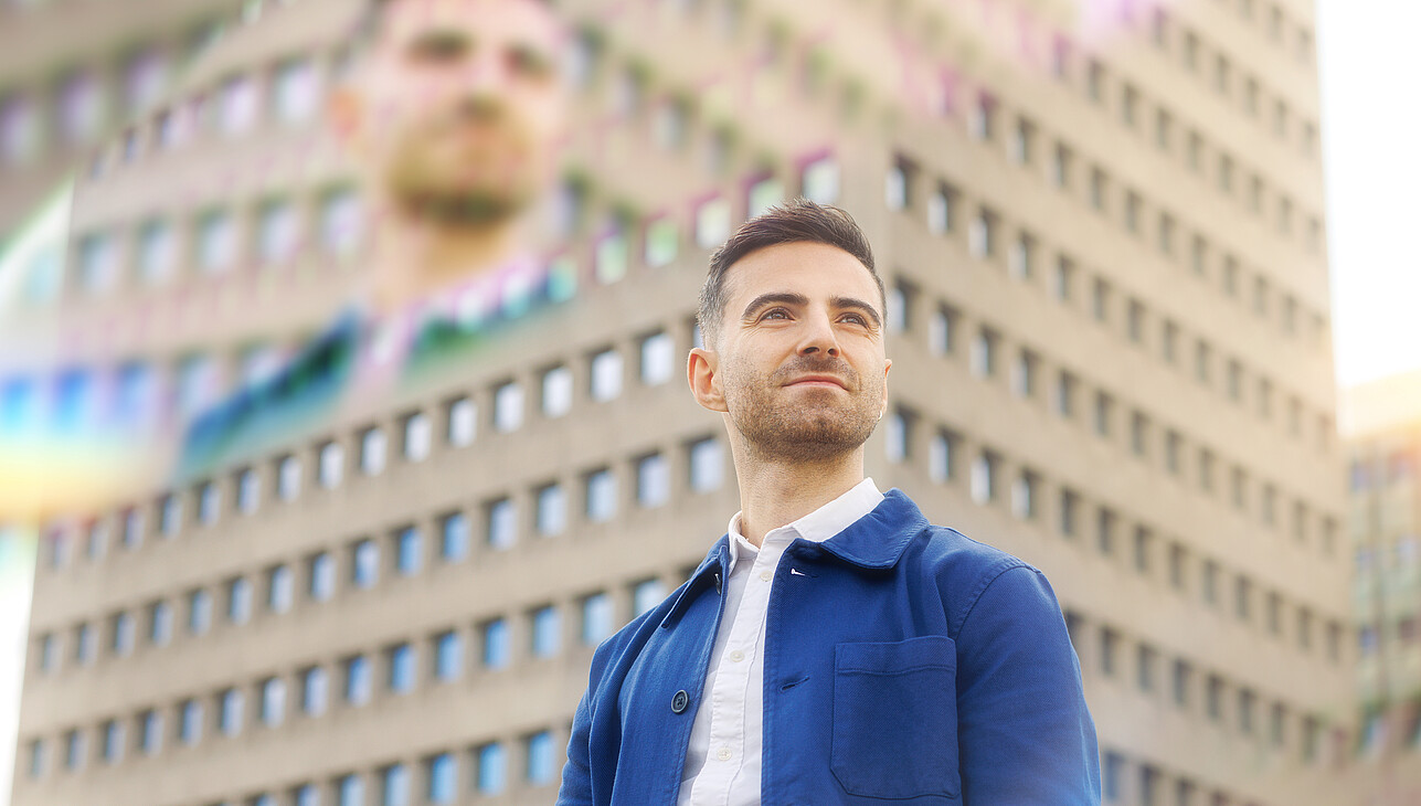 A man standing on the Erasmus University campus with prisms around him.