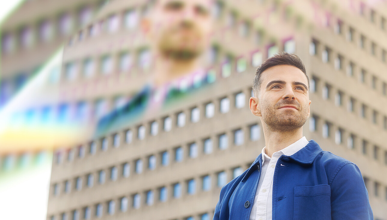 A man standing on the Erasmus University campus with prisms around him.