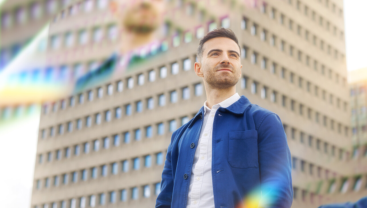 A man standing on the Erasmus University campus with prisms around him.
