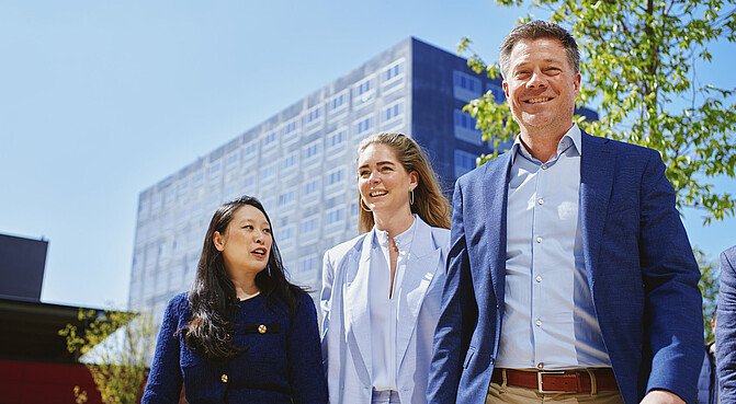 Student walking with parents on campus