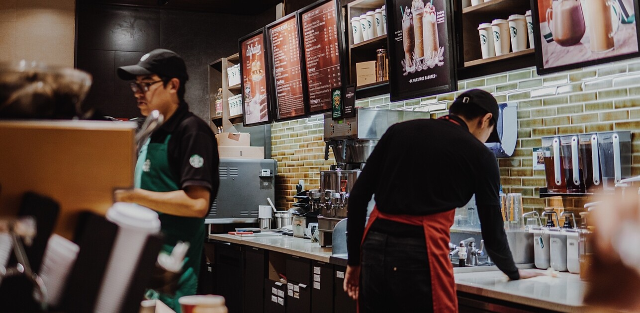 Two starbucks employees are shown