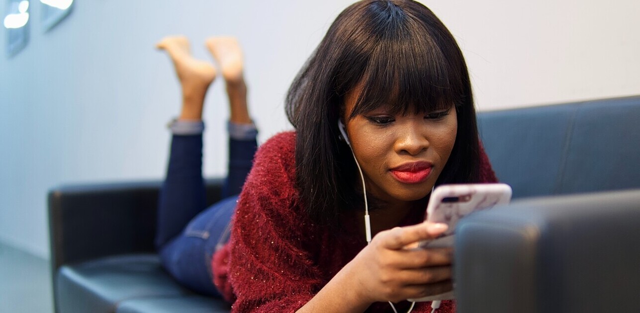 girl on the couch engaged with video on the phone