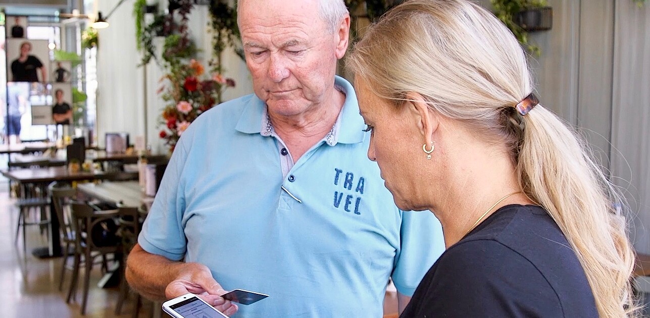 Elderly man paying with credit card.