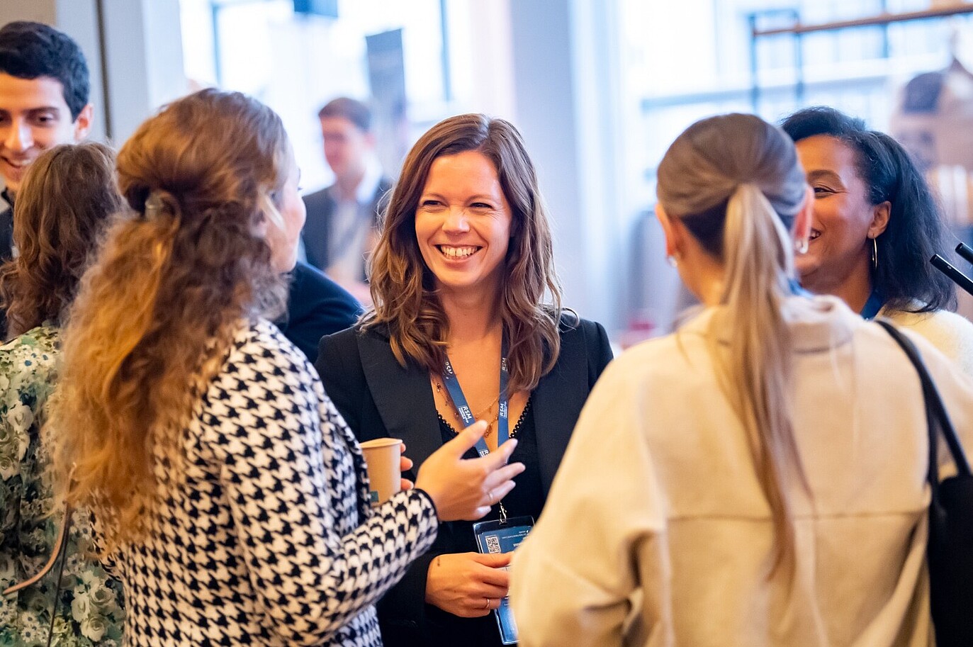 Alumni at a leadership summit enjoying a meaningful conversation with a young leader, fostering valuable connections and insights.