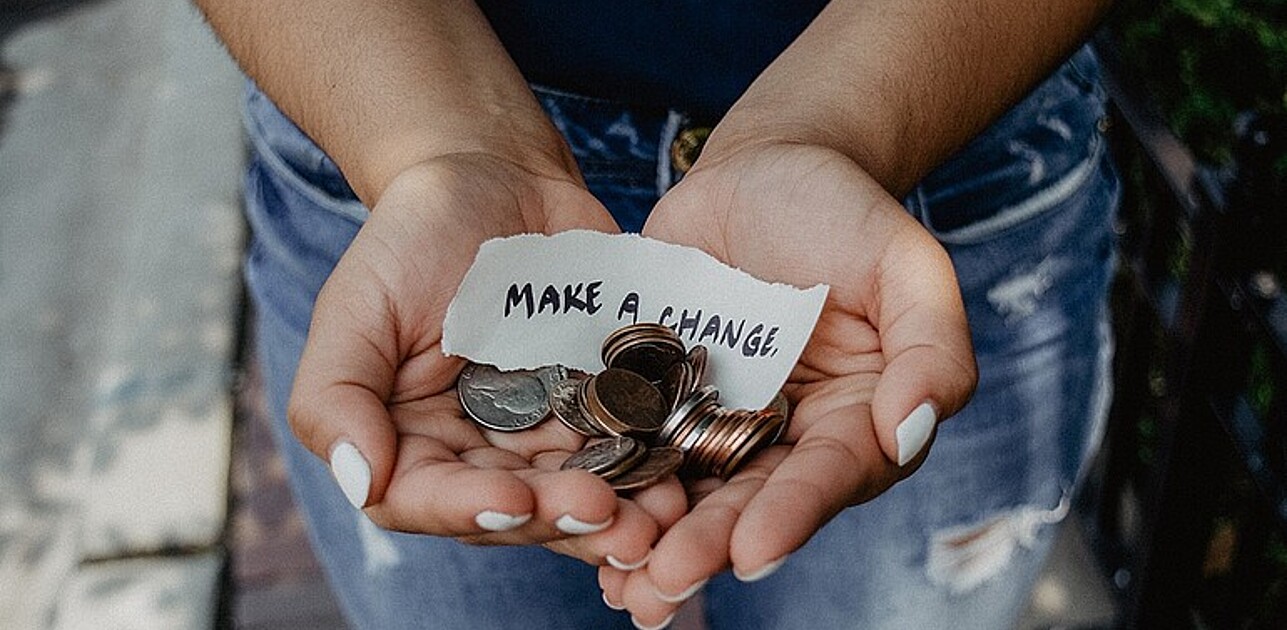 Hands holding up a letter stating make a change.